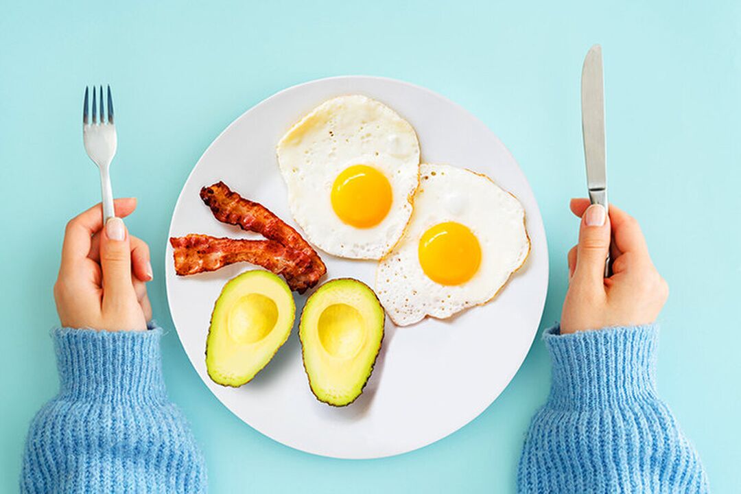 Das perfekte Frühstück auf der ketogenen Diätkarte Eier mit Bacon und Avocado